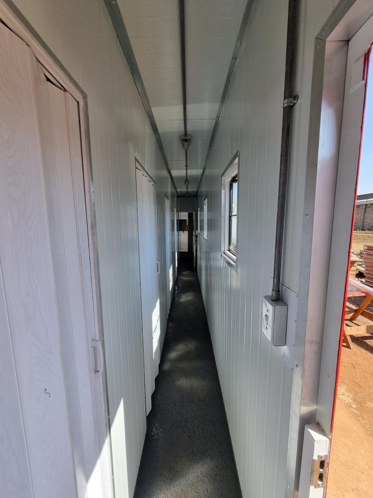 Concertina doors lead off the passage of the caboose container into two small bedrooms