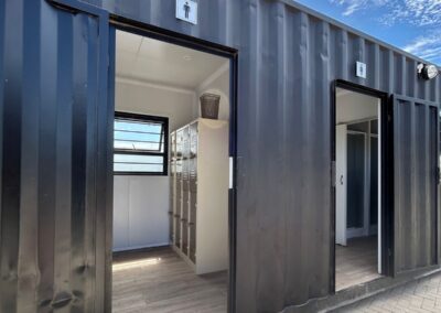 Converted shipping container into modern portable toilet facility with lockers.