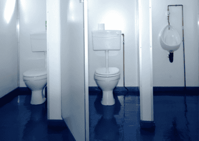 Public restroom with multiple toilet stalls and a urinal, clean and modern design.
